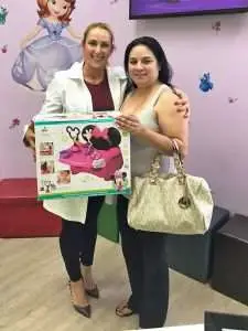 Two women holding a toy box