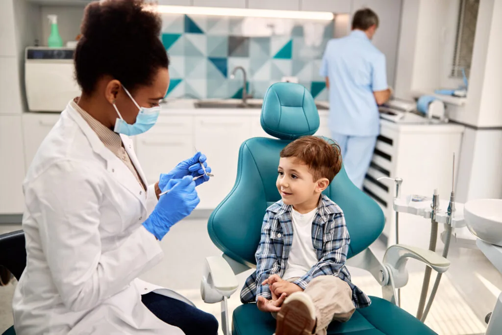 Niño pequeño hablando con el dentista antes de una revisión dental. 13/12/2024, 18:01:43 UTC