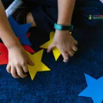 Niño acomodando figuras de estrellas de colores