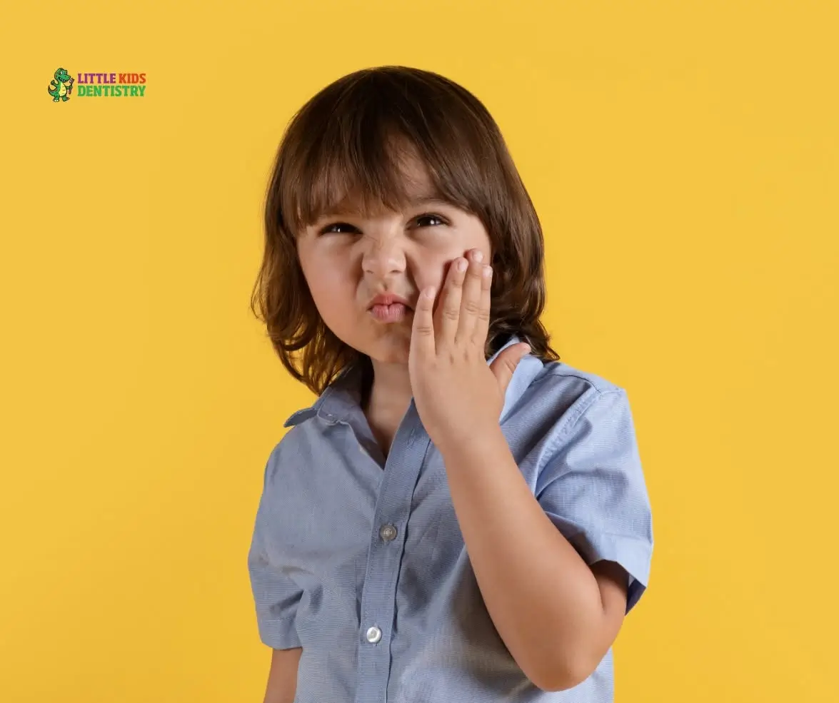 Child touching cheek, expressing discomfort.