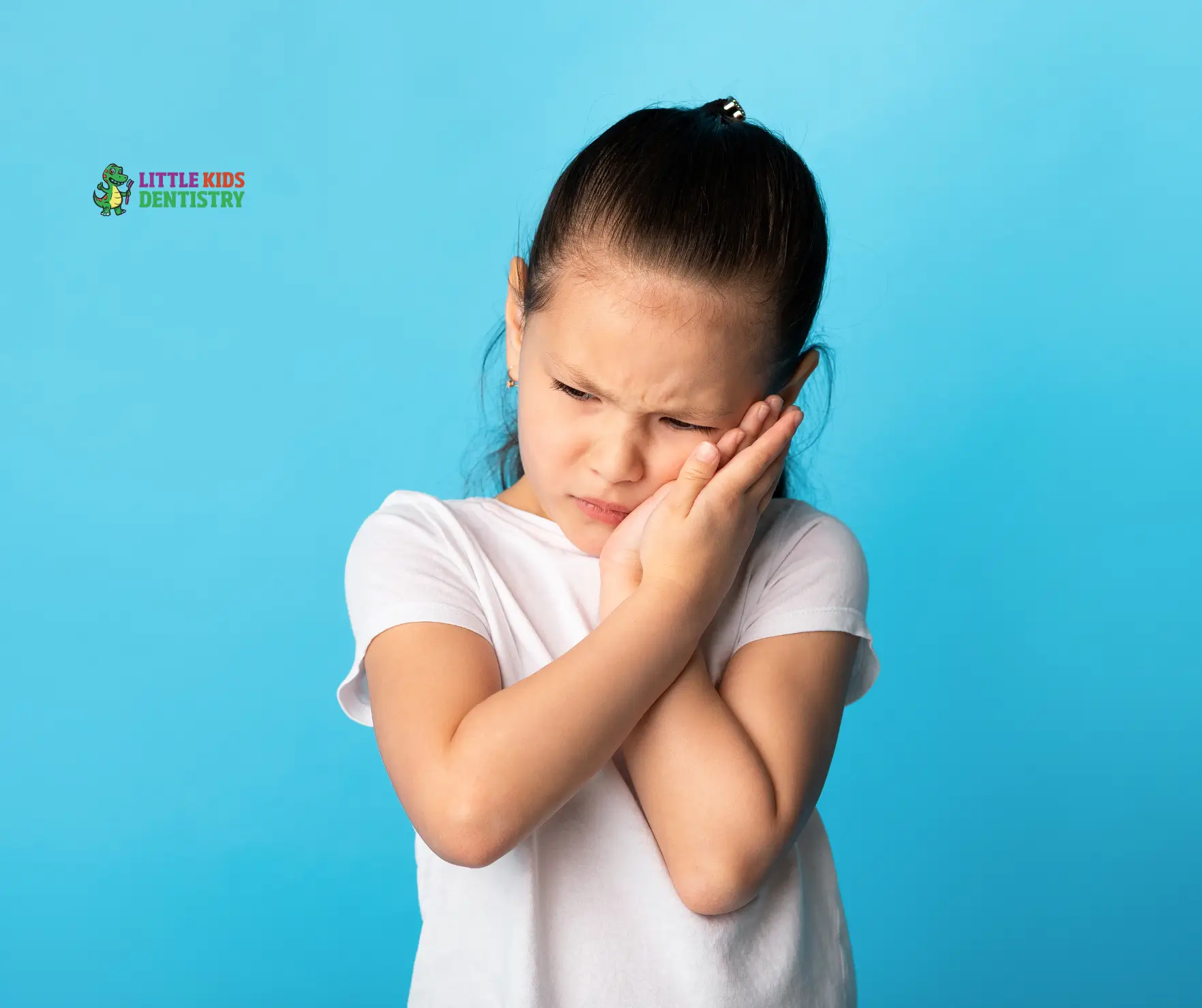 Child holding cheek, expressing discomfort.